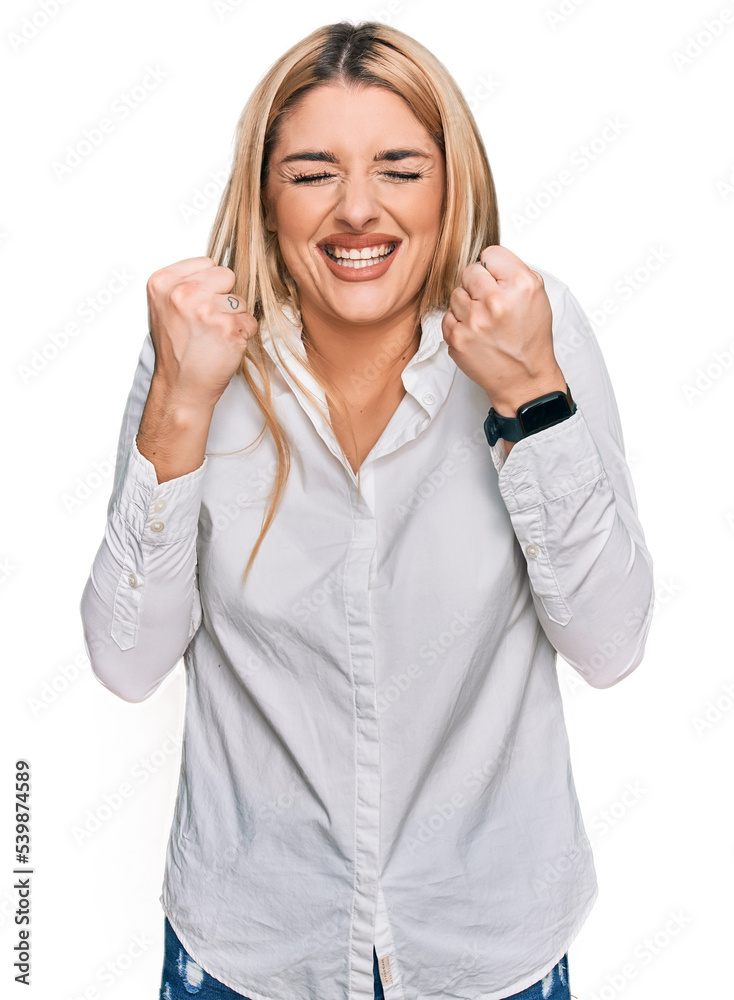 Young caucasian woman wearing casual clothes excited for success with arms raised and eyes closed celebrating victory smiling. winner concept. Young caucasian woman wearing casual clothes excited for success with arms raised and eyes closed celebrating victory smiling. winner concept.
