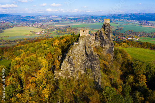 Aerial view of two towers of ruined abandoned Trosky Castle on tops of stone rocks domineering over Czech nature reserve 