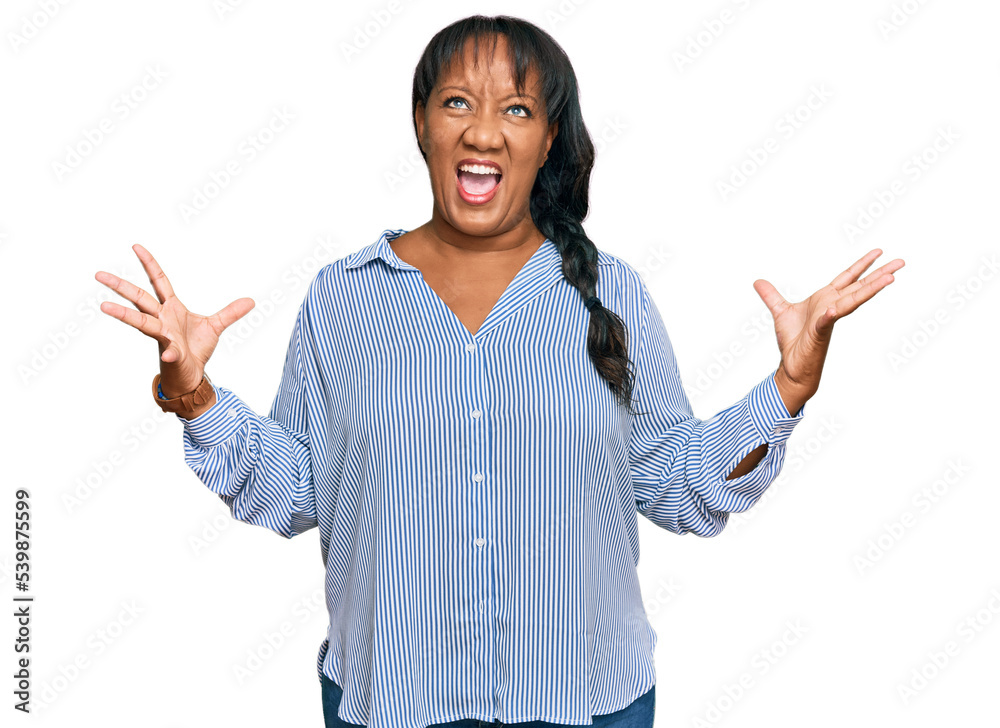 Hispanic middle age woman wearing casual clothes crazy and mad shouting and yelling with aggressive expression and arms raised. frustration concept. Hispanic middle age woman wearing casual clothes crazy and mad shouting and yelling with aggressive expression and arms raised. frustration concept.