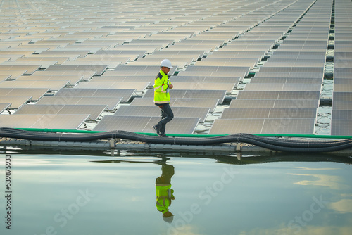 Portrait of professional man engineer working checking the panels at solar energy on buoy floating. Power plant with water, renewable energy source. Eco technology for electric power in industry.