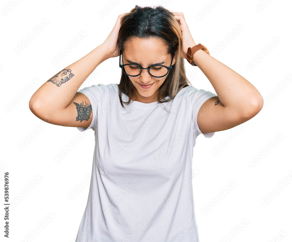 Young hispanic woman wearing casual white t shirt suffering from headache desperate and stressed because pain and migraine. hands on head. Young hispanic woman wearing casual white t shirt suffering from headache desperate and stressed because pain and migraine. hands on head.