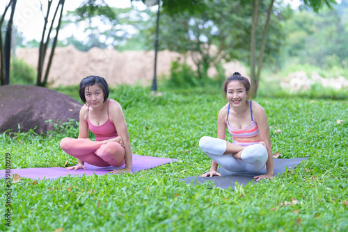 A beautiful young woman group of adults attending a yoga class outside the park., peace and relaxation, woman's happiness