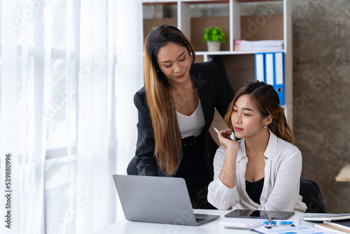 Two young Asian businessmen are excited about their success in winning online. and happy from good news e-mails in notebooks Inspired by great deals or new opportunities.