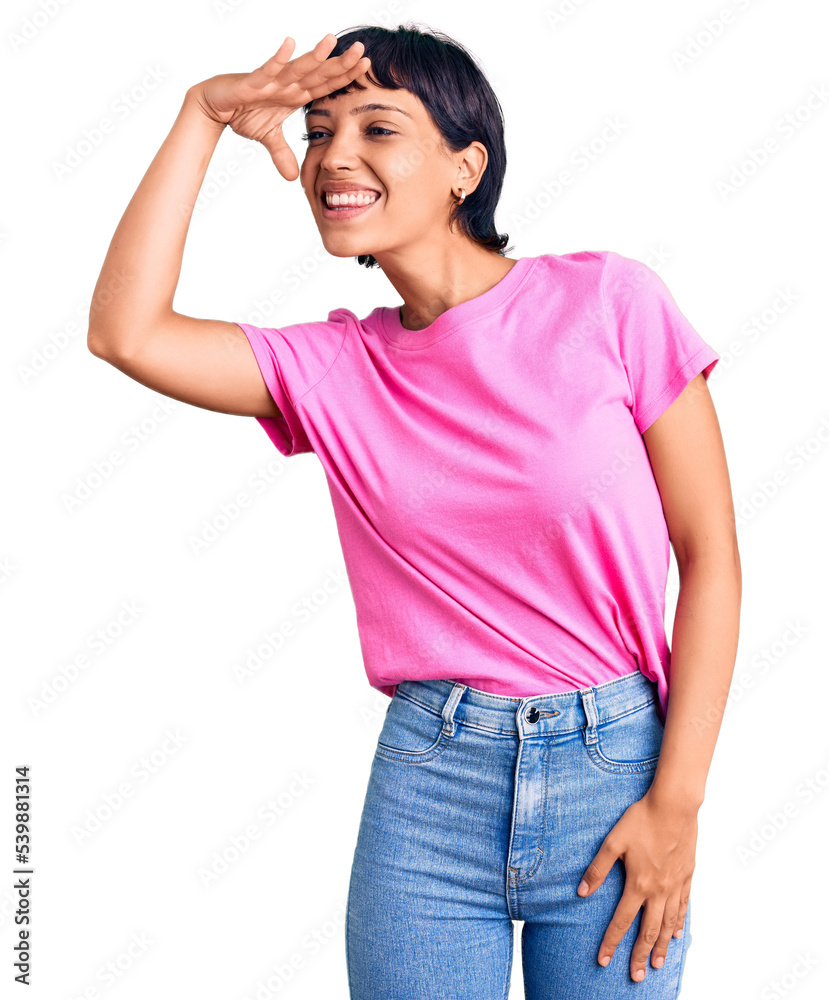 Young brunette woman with short hair wearing casual clothes very happy and smiling looking far away with hand over head. searching concept. Young brunette woman with short hair wearing casual clothes very happy and smiling looking far away with hand over head. searching concept.