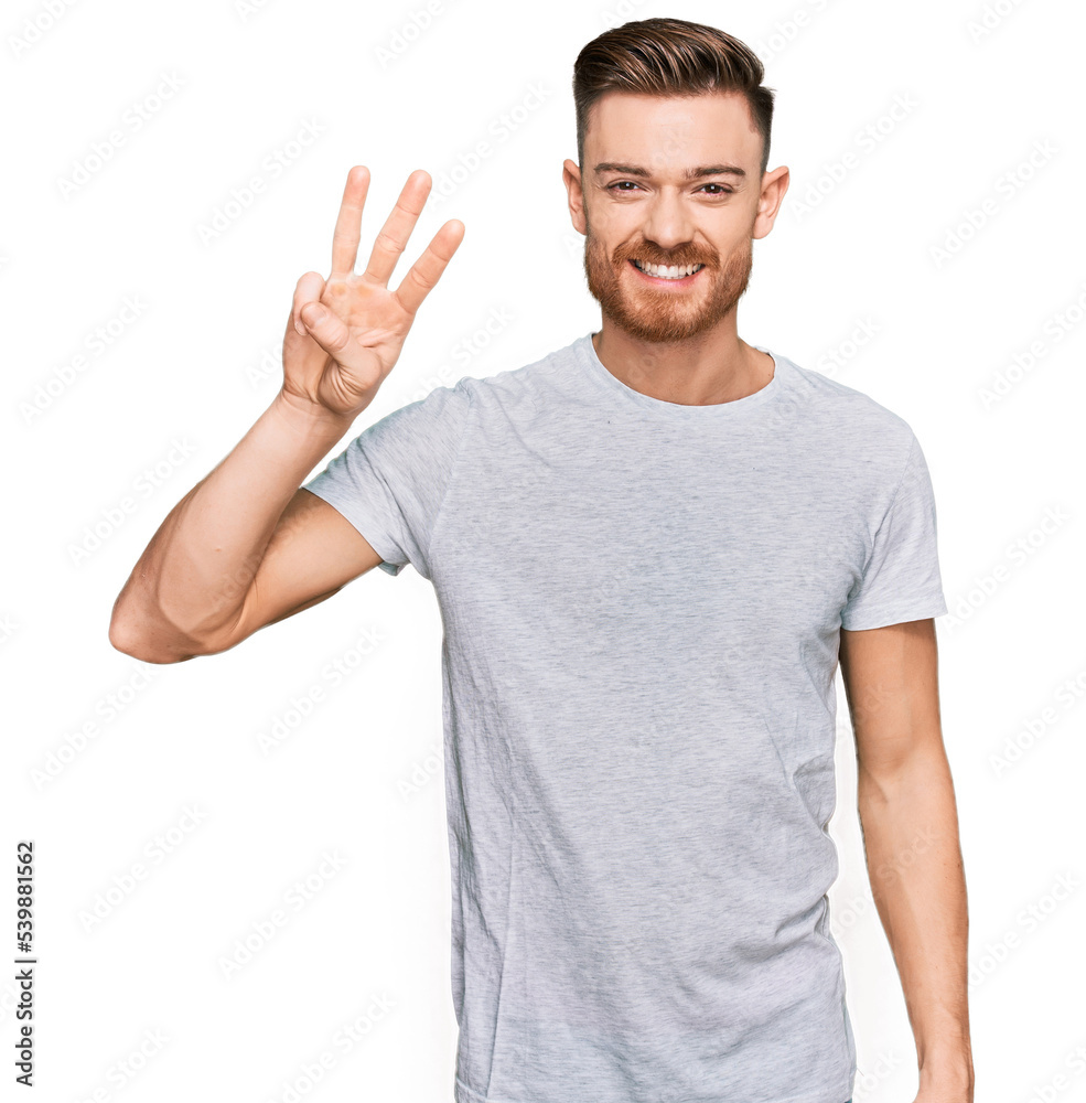 Young redhead man wearing casual grey t shirt showing and pointing up with fingers number three while smiling confident and happy. Young redhead man wearing casual grey t shirt showing and pointing up with fingers number three while smiling confident and happy.
