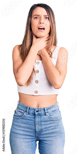 Young beautiful girl wearing casual sleeveless t shirt shouting and suffocate because painful strangle. health problem. asphyxiate and suicide concept.