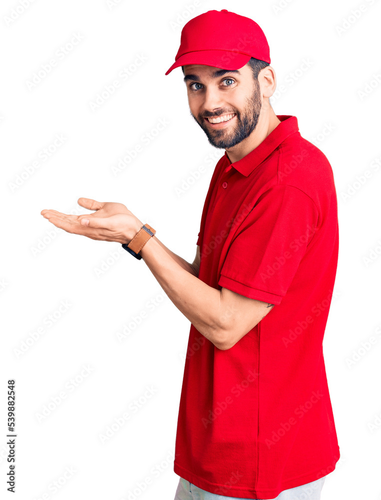 Young handsome man with beard wearing delivery uniform pointing aside with hands open palms showing copy space, presenting advertisement smiling excited happy Young handsome man with beard wearing delivery uniform pointing aside with hands open palms showing copy space, presenting advertisement smiling excited happy