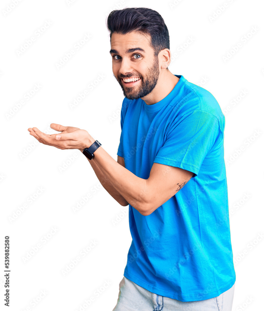 Young handsome man with beard wearing casual t-shirt pointing aside with hands open palms showing copy space, presenting advertisement smiling excited happy Young handsome man with beard wearing casual t-shirt pointing aside with hands open palms showing copy space, presenting advertisement smiling excited happy