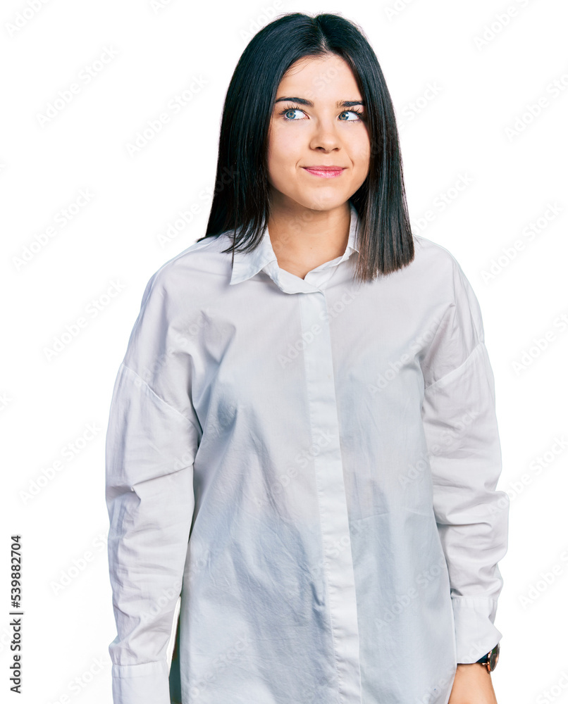 Young brunette woman with blue eyes wearing oversize white shirt smiling looking to the side and staring away thinking. Young brunette woman with blue eyes wearing oversize white shirt smiling looking to the side and staring away thinking.