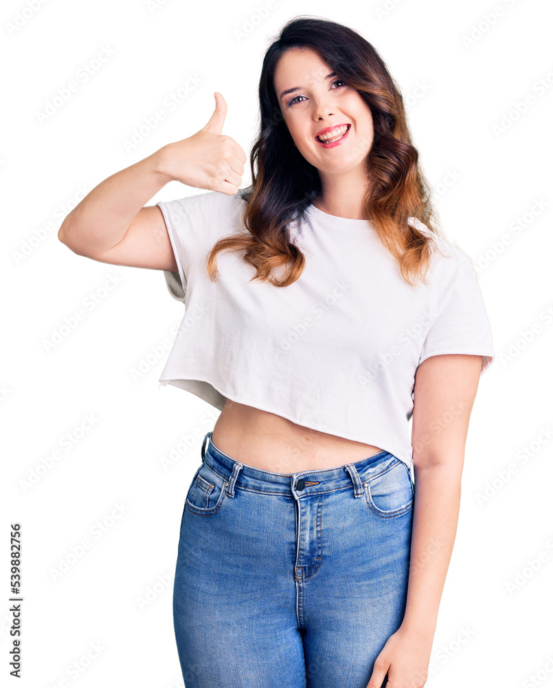 Obraz premium Beautiful young brunette woman wearing casual clothes smiling happy and positive, thumb up doing excellent and approval sign