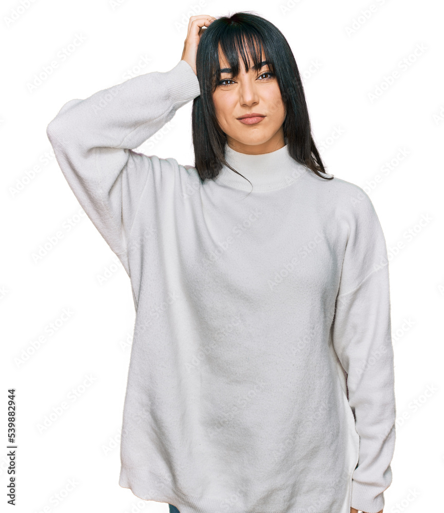 Young brunette woman with bangs wearing casual turtleneck sweater confuse and wonder about question. uncertain with doubt, thinking with hand on head. pensive concept. Young brunette woman with bangs wearing casual turtleneck sweater confuse and wonder about question. uncertain with doubt, thinking with hand on head. pensive concept.