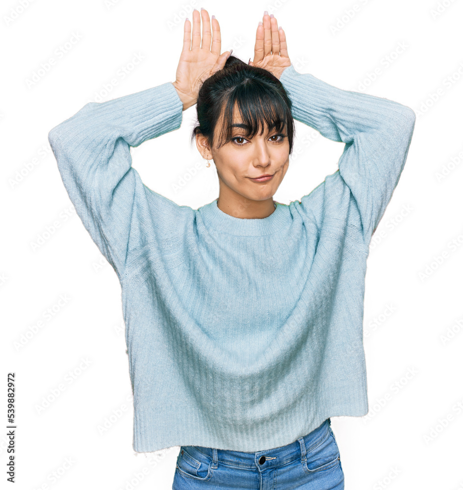 Young hispanic woman wearing casual clothes doing bunny ears gesture with hands palms looking cynical and skeptical. easter rabbit concept.