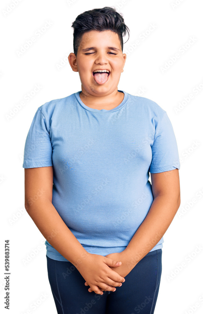 Little boy kid wearing sports workout clothes sticking tongue out happy with funny expression. emotion concept.