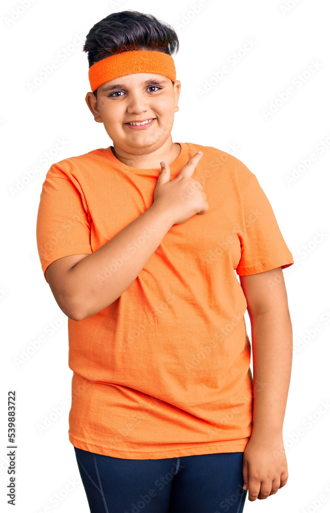Little boy kid wearing sportswear cheerful with a smile on face pointing with hand and finger up to the side with happy and natural expression Little boy kid wearing sportswear cheerful with a smile on face pointing with hand and finger up to the side with happy and natural expression