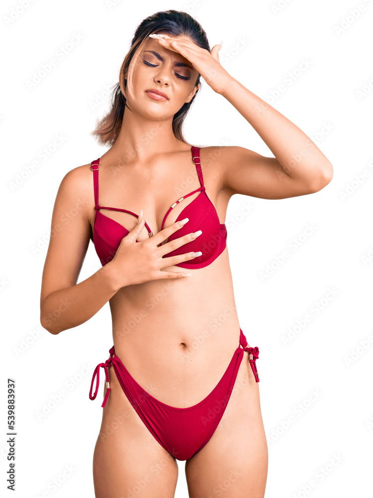 Obraz premium Young beautiful woman wearing bikini touching forehead for illness and fever, flu and cold, virus sick