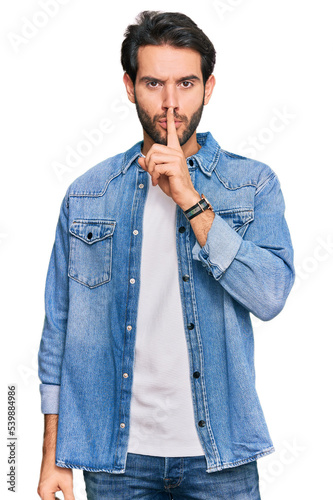 Young hispanic man wearing casual clothes asking to be quiet with finger on lips. silence and secret concept.