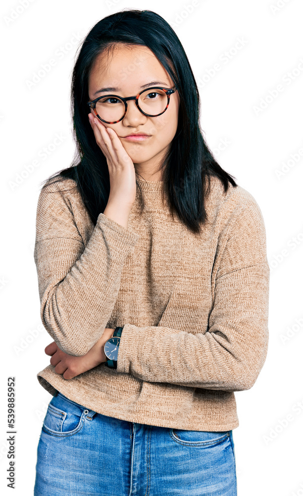 Young chinese woman wearing casual sweater and glasses thinking looking tired and bored with depression problems with crossed arms. Young chinese woman wearing casual sweater and glasses thinking looking tired and bored with depression problems with crossed arms.
