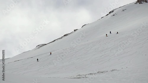 Group of skier skiing down mountain offpiste at high altitude powder snow photo