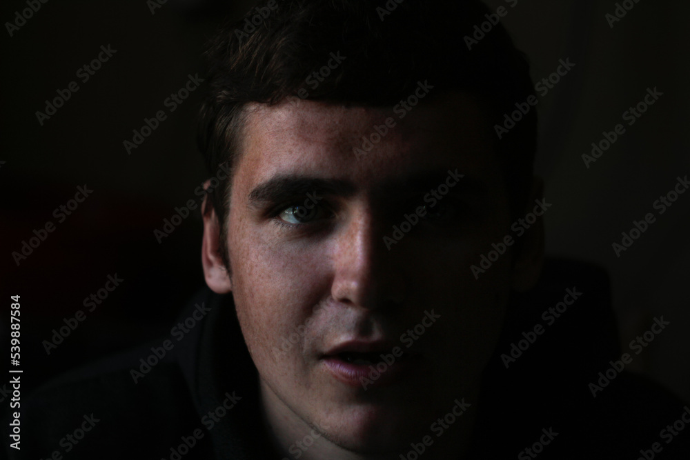 Defocus low key portrait of young man. Male head front silhouette. Dramatic 20s portrait face men with open mouth. Out of focus