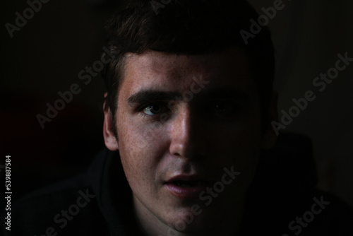 Defocus low key portrait of young man. Male head front silhouette. Dramatic 20s portrait face men with open mouth. Out of focus