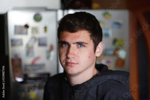 Defocus portrait young man indoors background. Serious young man with blue eyes. 20s years. Handsome man outdoors portrait. Lifestyle. Student. Closeup. Out of focus photo