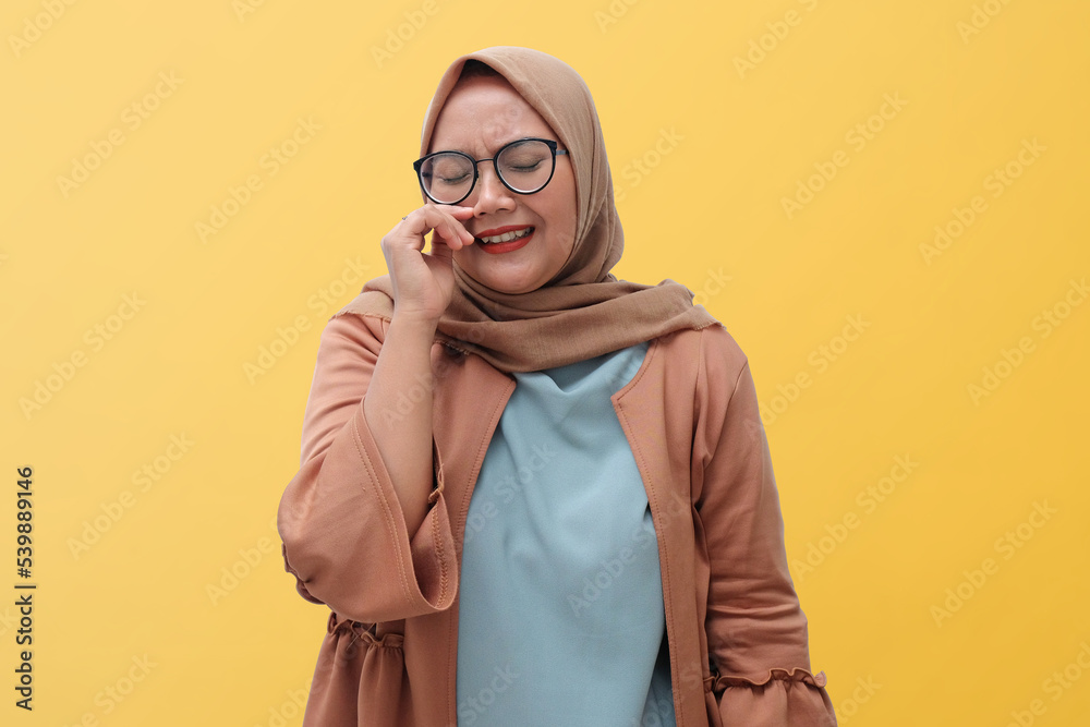 sad Muslim woman crying isolated in yellow background sad Muslim woman crying isolated in yellow background