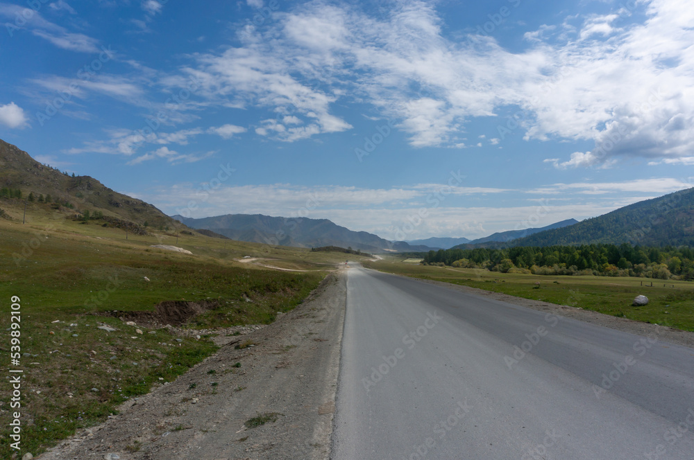 Asphalt road in a valley between low mountains in the Republic of Altai Mountains