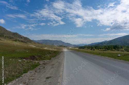 Asphalt road in a valley between low mountains in the Republic of Altai Mountains photo