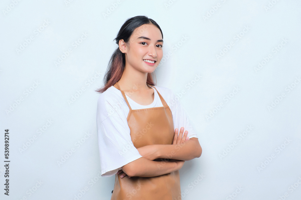 Obraz premium Smiling pretty young barista girl in apron standing with crossed arms feels confident isolated on white background