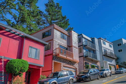 Houses on a steep street in San Francisco residential area against blue sky