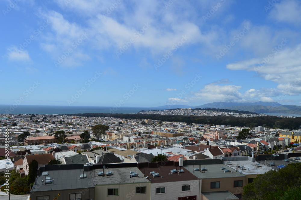 View over several western neighborhoods in San Francisco, including Golden Gate Park, with the Pacific Ocean visible in the background.