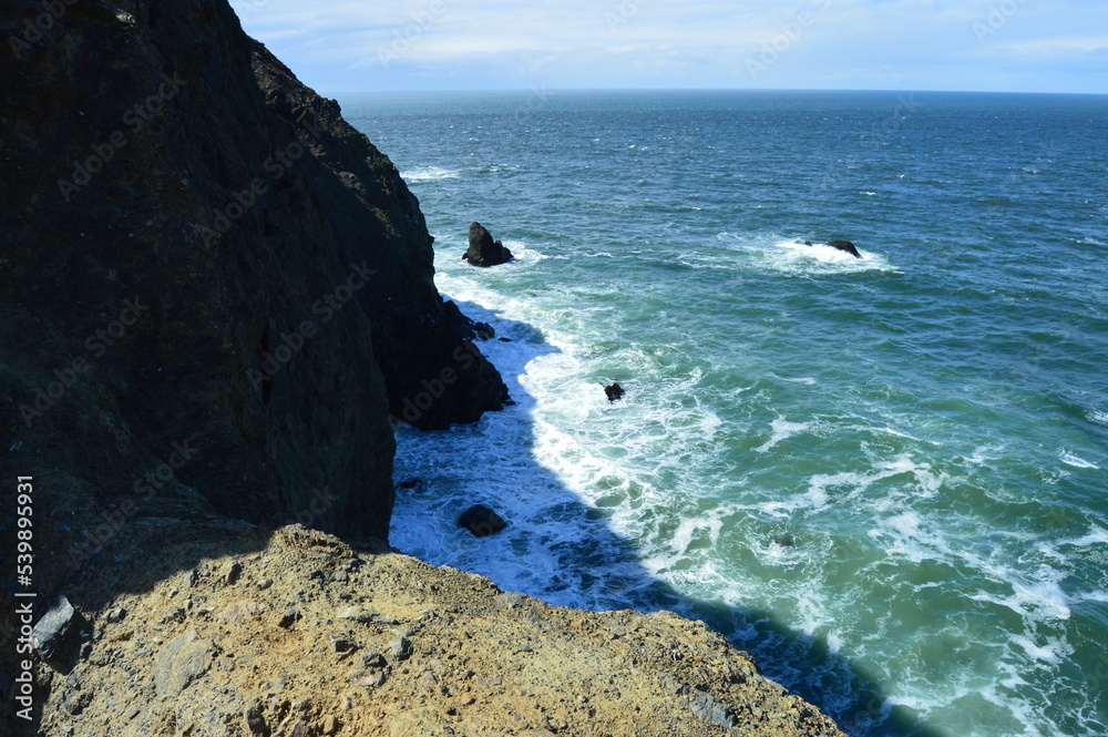 Sea cliffs and waves breaking onto rocks along the Pacific coast of Marin County, California. 