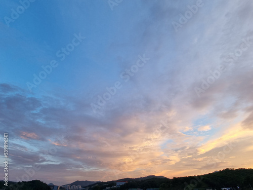 cloud and vanilla sky background with dark mountain silhouette © binimin