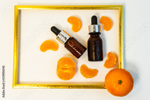 A bottle of essential oil, Aromatic tangerine oil in a dark bubble, cosmetic oil from tangerine. Bottles with sweet orange essential oil extract, tincture, infusion, perfume. Selective focus. 
