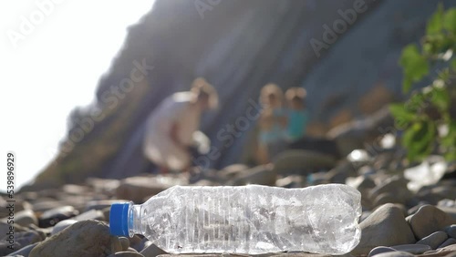 Wallpaper Mural Little siblings helping mother to collect garbage on sea beach blurred on the background of plastic bottle.Family activists collecting trash.Concept of environmental conservation pollution problems. Torontodigital.ca