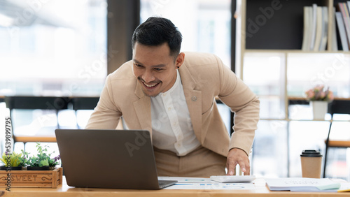Businessman using calculator and laptop for do math finance on wooden desk in office and business working background, tax, accounting, statistics and analytic research concept