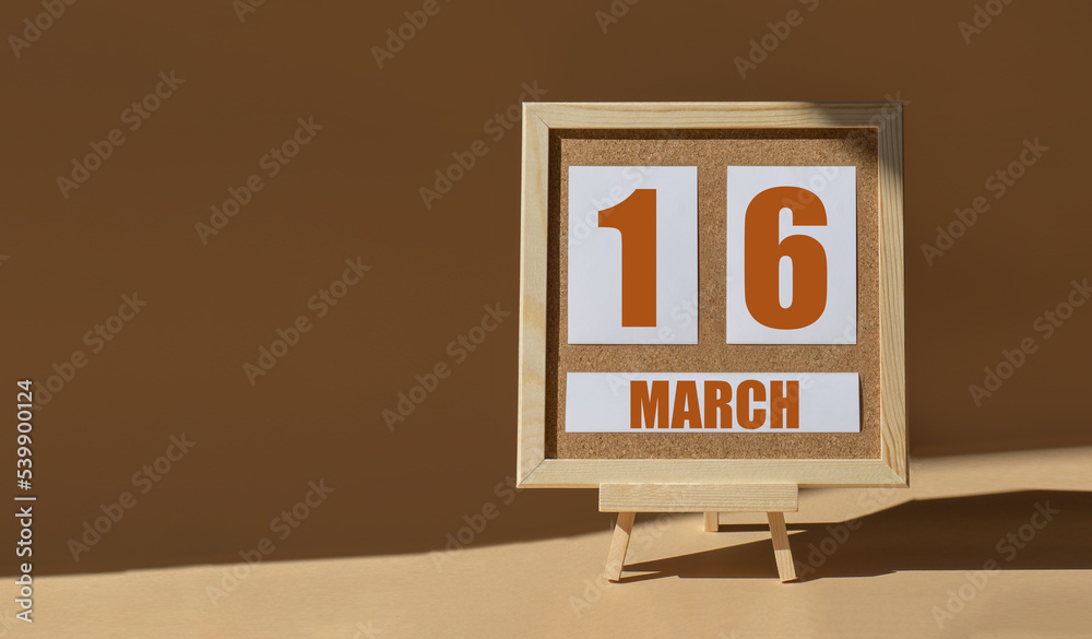 March 16th. Day 16 of month, Calendar date. Cork board, easel in sunlight on desktop. Close-up, brown background. Spring month, day of year concept March 16th. Day 16 of month, Calendar date. Cork board, easel in sunlight on desktop. Close-up, brown background. Spring month, day of year concept