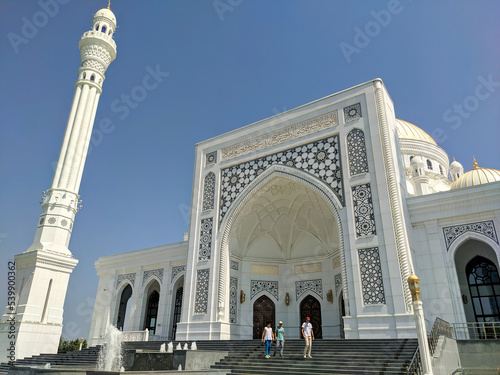 Shali, Chechen Republic, Russia - August 17, 2022: Beautiful view of the white mosque Pride of Muslims named after the Prophet Muhammad. Tourists descend the stairs