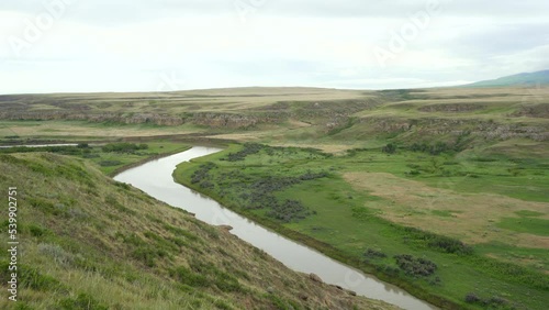 Writing on Stone Provincial Parks bandlands and Hoodoos in a desert in Alberta, Canada during overcast day with river at a distance. photo