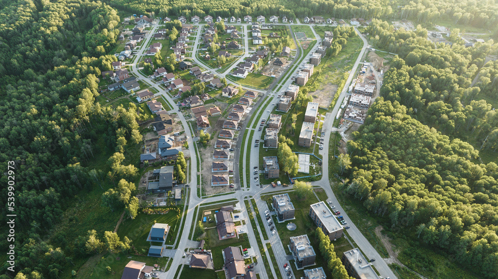 Small modern village in summer at sunset. Aerial view Small modern village in summer at sunset. Aerial view