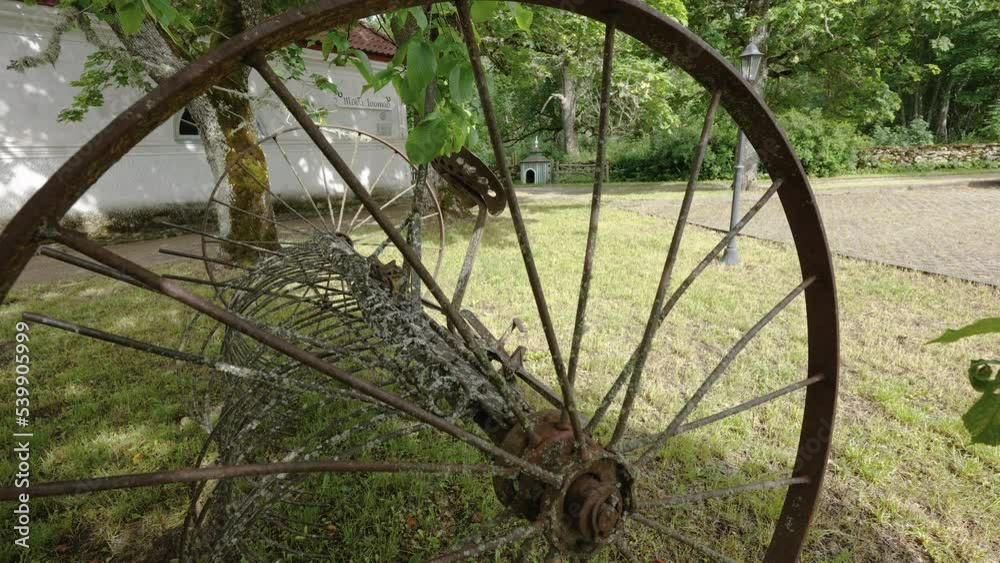 The rusty and broken wheels outside the house in the yard in Estonia The rusty and broken wheels outside the house in the yard in Estonia