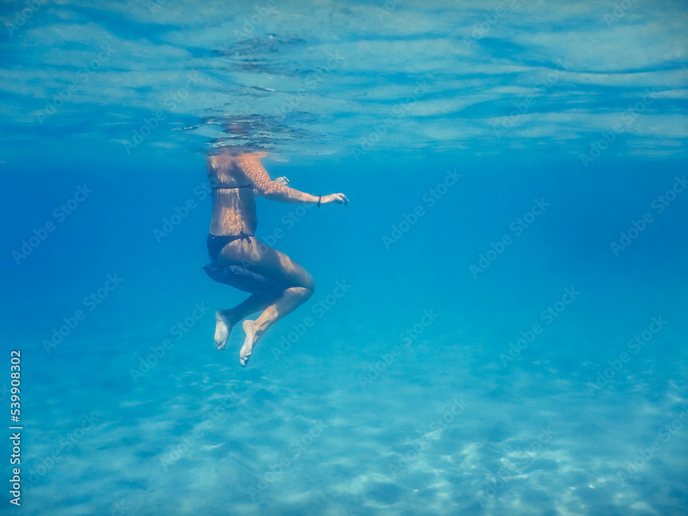 woman hover in clear water on vacation in egypt