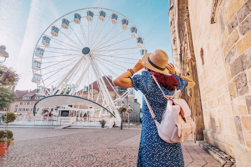 Φωτογραφία traveler girl at an amusement fair with a Ferris wheel in the old European city