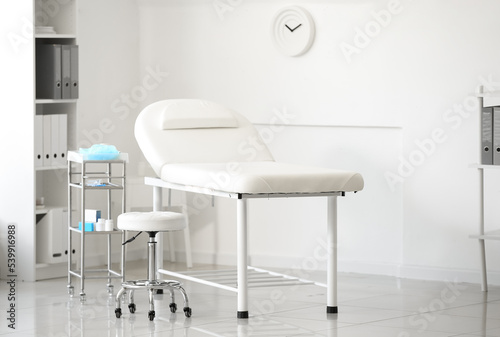 Interior of modern medical office with couch and table with doctor's supplies