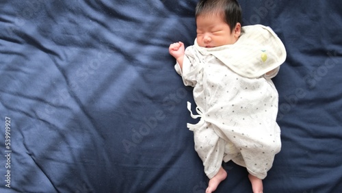 産後1か月0歳の新生児が寝ているときの全身を撮影した右寄りの俯瞰写真 photo