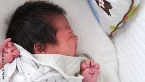 産後1か月0歳の新生児が泣いている横顔をアップで撮影した左寄りの写真 photo