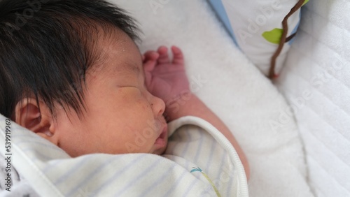 産後1か月0歳の新生児が寝ている横顔をアップで撮影した左寄りの写真 photo