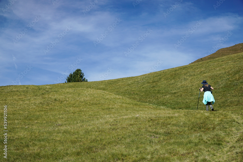 Obraz premium Young sporty hiker woman is hiking in the italian dolomites and enyos nature. travel and holiday concept.