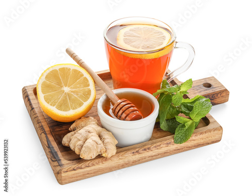 Board with glass of black tea, lemon, mint, ginger and honey on white background