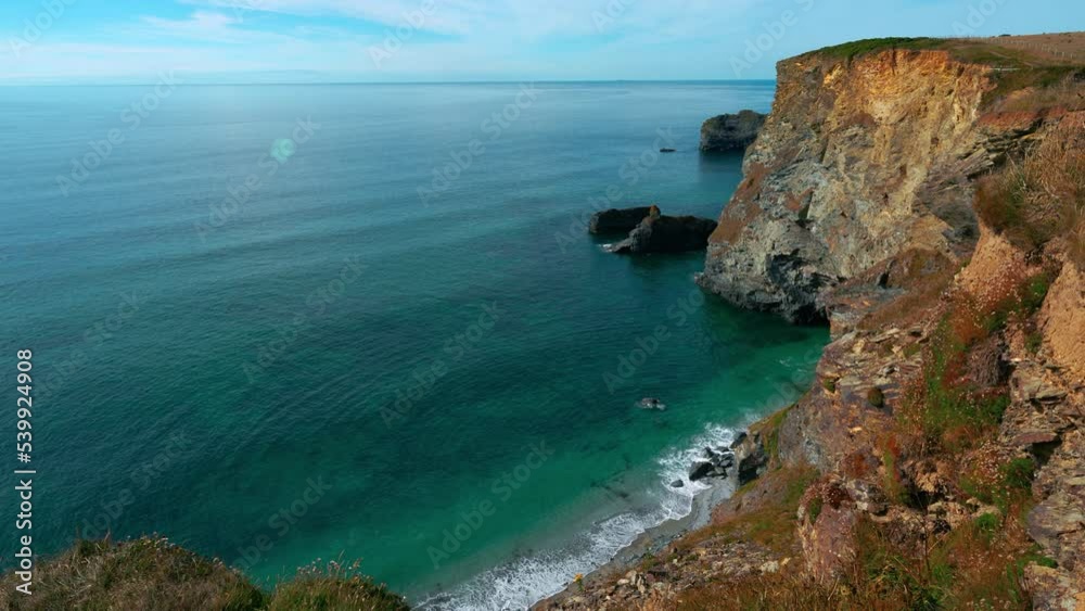 Cinemagraph seamless video loop of a cliff seaside beach close to St Ives in Cornwall, England, UK. The water is blue, turquoise and clear and green grass patches are on the hills. Wide panoramic view Cinemagraph seamless video loop of a cliff seaside beach close to St Ives in Cornwall, England, UK. The water is blue, turquoise and clear and green grass patches are on the hills. Wide panoramic view